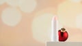 Pink moisturizing hygienic lipstick on a pedestal with a Christmas ball. Lip care in winter. Copy space