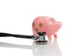 Pink money pigg with stethoscope