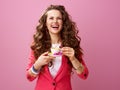 Cheerful young woman with cup of coffee and chocolate candies Royalty Free Stock Photo