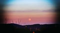 Pink moon against sunset and clouds in Germany