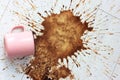 Pink mug, cup fell on white parquet floor and left a big stain. Spilled coffee.