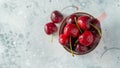 Pink mug with fresh ripe cherries. Sweet organic berries on a light concrete background. Top view with copy space