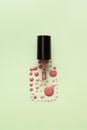 Pink nail polish bottle silhouette made from nail polish drops and splashes isolated on green background Royalty Free Stock Photo