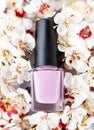 Pink nail polish bottle on spring cherry blossom background. Pink nail polish bottle on flower background Royalty Free Stock Photo