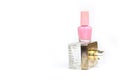 Pink nail polish small glass bottle and perfume spray bottle. Layout stack of two unbranded cosmetic bottles on white background.