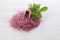 Pink natural bath salt on white wooden background with mint leaf Royalty Free Stock Photo