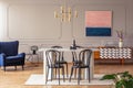 Pink and navy blue abstract painting on a gray wall with molding in an elegant dining and living room