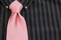 Pink necktie tied on black pinstriped shirt