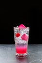 Pink roses, cherries, Italian soda, sparkling, clear glass of water on a black background Royalty Free Stock Photo