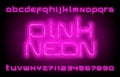 Pink Neon alphabet font. Neon light modern letters and numbers on brick wall background. Royalty Free Stock Photo