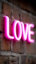 A pink neon sign that says LOVE on a brick wall Royalty Free Stock Photo