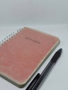 Pink note book and pen isolated white background Royalty Free Stock Photo