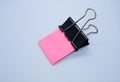 Pink note paper with black binder clip. Binder clip and stack of pink note paper Royalty Free Stock Photo