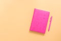 Pink notebook and ballpoint pen on a pastel yellow background. Top view, flat lay, copy space Royalty Free Stock Photo