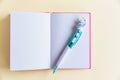 Pink notebook for notes, funny unicorn pen on yellow pastel background. Flat lay. Top view. Copy space Royalty Free Stock Photo