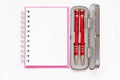 Pink notebook with two red pen in box on white background Royalty Free Stock Photo