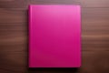 A pink notepad for writing lies on a wooden desktop
