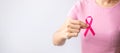 Pink October Breast Cancer Awareness month, woman hand hold pink Ribbon and wear shirt for support people life and illness. Royalty Free Stock Photo