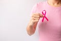 Pink October Breast Cancer Awareness month, woman hand hold pink Ribbon and wear shirt for support people life and illness. Royalty Free Stock Photo