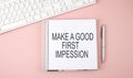 Pink office desk with keyboard and notebook , text MAKE A GOOD FIRST IMPRESSION Royalty Free Stock Photo