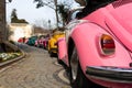 Pink old convertible car behind most of the other old, colorful cars Royalty Free Stock Photo