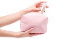 Pink open cosmetic bag in female hands with base cream beige