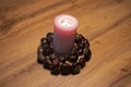 Pink open-fire candle with decorative chestnuts ring Royalty Free Stock Photo