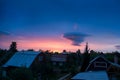 Pink orange purple sunset over the city. Multicolored sky and black silhouettes of private houses and cottages