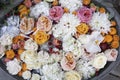 orange roses, blue hydrangea, red cranberries, white chrysanthemums, tangerines in water in a tin basin as a flower shop