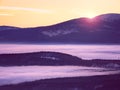 Pink orange sun rise above misty winter mountains Royalty Free Stock Photo