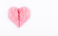 Pink origami heart on a white background. A valentine made of paper.
