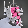 Pink overlock on a grey background. Equipment for sewing production. Sewing clothes and textiles. 3d illustration