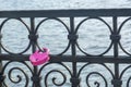 Pink padlock in shape of heart on forged metal border of bridge on the river. Symbol of love and fidelity of the newlyweds. Royalty Free Stock Photo