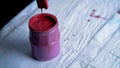 Pink paint flowing from brush into bank. Can of paint on table on black background. Process of preparing materials for Royalty Free Stock Photo