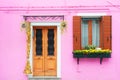 Pink painted facade of the house, door and window with flowers. Burano, Italy Royalty Free Stock Photo