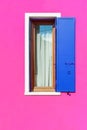 Pink painted facade of the house and window with blue shutters. Burano, Venice, Italy Royalty Free Stock Photo