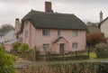 Pink painted thatched house in the winter Royalty Free Stock Photo