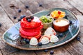 Pink pancakes with honey, chocolate, jam, whipped cream, berries and fruits on plate. Royalty Free Stock Photo