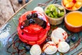 Pink pancakes with honey, chocolate, jam, whipped cream, berries and fruits on plate. Royalty Free Stock Photo