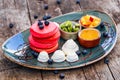 Pink pancakes with honey, chocolate, jam, whipped cream, berries and fruits on plate. Royalty Free Stock Photo