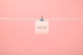 Pink paper note on clothesline with text Vote Royalty Free Stock Photo