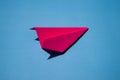 Pink Paper Plane or Paper Airplane Origami on Blue Background Top View with Place for Text, business competition concept Royalty Free Stock Photo