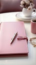 A pink paper planner and a notepad and pen lie on the table. Businesswoman concept. Vertical image.