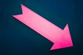Pink paper right arrow on dark blue background. Royalty Free Stock Photo