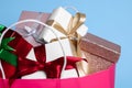 Pink paper shopping bag full of gift boxes on light blue background, closeup Royalty Free Stock Photo