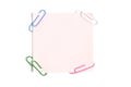 Pink paper sticker for written notes and paper clips on a white background Royalty Free Stock Photo