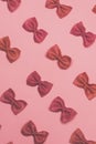 Pink pasta farfalle lies diagonally