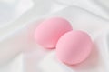 Pink pastel easter eggs on white satin textile background Royalty Free Stock Photo