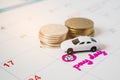 pink pay day word on calendar with marked 25th date and blurred miniature car