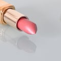 Pink pearlescent lipstick on a light background
